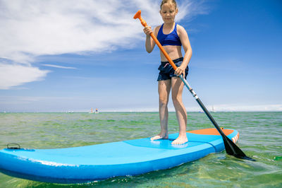 Boy on sea shore against sky