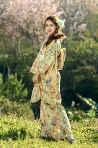 Portrait of young woman standing on tree