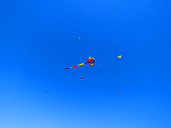 Low angle view of airshow against clear blue sky