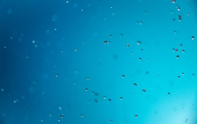 Full frame shot of bubbles against blue sky