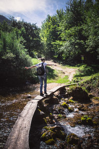 Rear view of man standing by stream