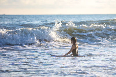 Man surfing in sea against sky