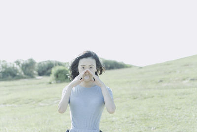 Portrait of beautiful woman blowing gum against clear sky