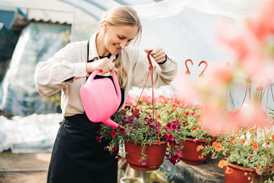 Professional girl gardener grows flowers in a greenhouse. daily care of plants. garden center