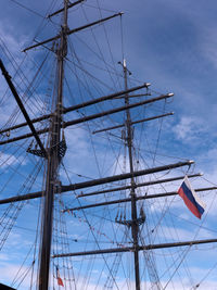 Low angle view of masts against blue sky