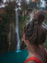 Side view of woman looking at waterfall