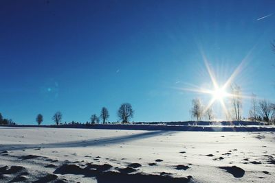 Scenic view of snow field against clear blue sky