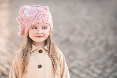 Cute girl looking away standing on footpath