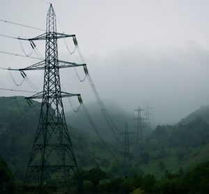 Low angle view of electricity pylon in foggy weather