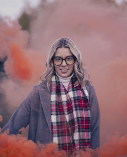 Portrait of young woman standing against sky during sunset