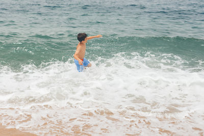 Woman jumping in sea