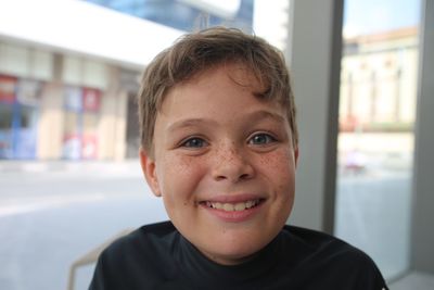 Close-up portrait of smiling boy at cafe