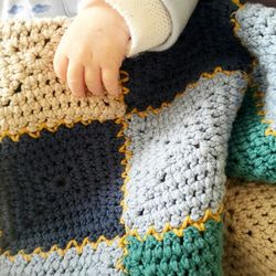 Cropped hand of baby holding knitted fabric
