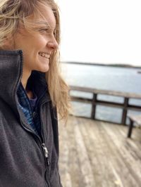 Smiling woman standing by sea