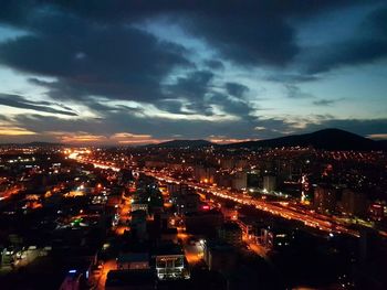 Illuminated cityscape against sky at night