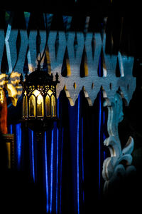 Close-up of illuminated lighting equipment hanging on window