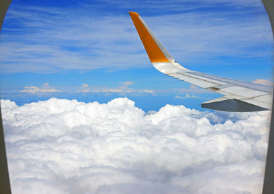 Cropped image of airplane flying over cloudscape