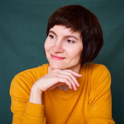 Smiling mature brunette woman looking away playful and defiant, close-up face