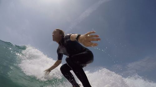 Low angle view of man surfboarding in sea