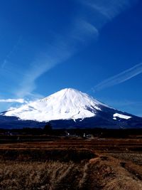 Scenic view of snowcapped mountains against blue sky