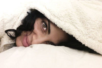 Close-up of woman lying on bed at home