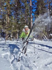 Portrait of young woman skiing against trees against forest