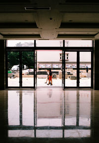 Rear view of woman standing on glass window