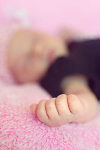 Close-up of baby hand on bed