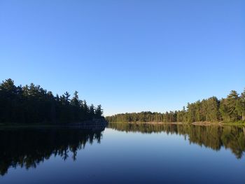 Scenic view of lake against clear blue sky