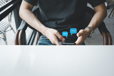 Midsection of man using mobile phone