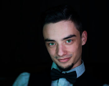 Close-up portrait of young man against black background