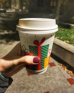 Close-up of hand holding coffee cup