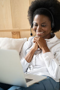 Smiling woman talking on video call at home