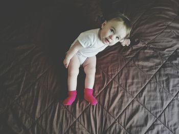 Portrait of baby girl on bed at home