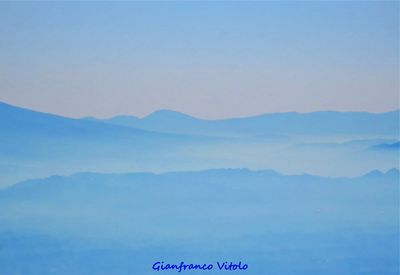 Scenic view of mountains against blue sky