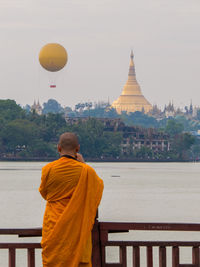 Rear view of man outside temple against building