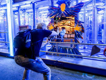 Rear view of man standing at illuminated stage