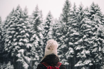 Close-up of person standing by tree against sky during winter
