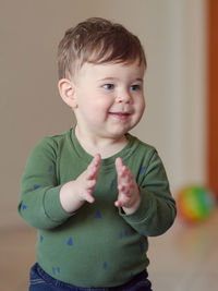 Cute toddler clapping his hands at home