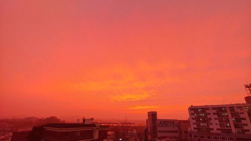 Buildings against dramatic sky during sunset