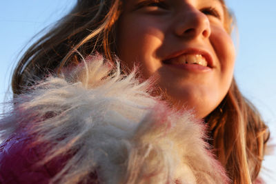 Close-up portrait of smiling girl against sky