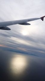 Cropped image of airplane flying over cloudscape