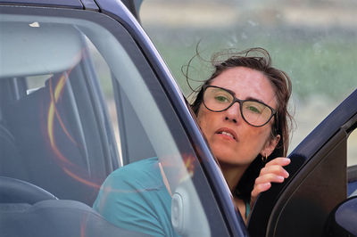 Portrait of young woman sitting in car