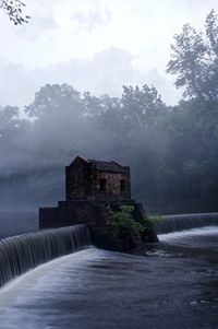 Built structure by water against sky