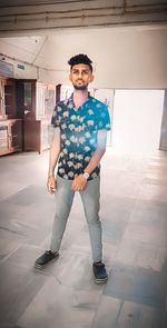 Portrait of young man standing on tiled floor