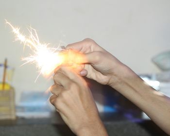 Close-up of hand holding lit candle