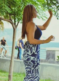 Rear view of woman standing against trees