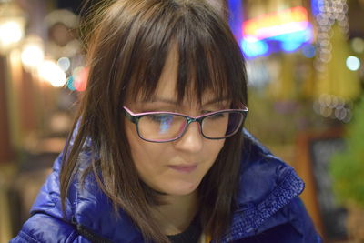 Portrait of woman wearing eyeglasses at night