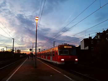 Railroad tracks against cloudy sky