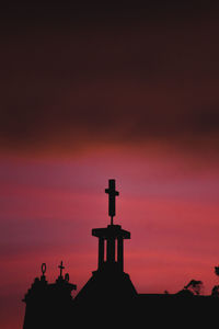 Silhouette temple against building during sunset